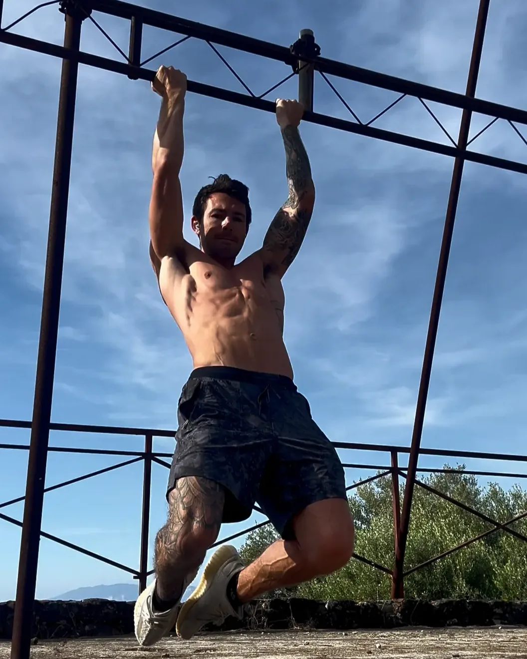 Tyler doing a hanging leg raise on an outdoor pull-up bar